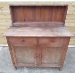 Early/mid C20th dresser with two drawers above two doors on block supports and turned wood