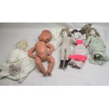 Three various dolls and a collection of dolls clothing