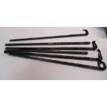 Collection of six ebony walking sticks with bone inlay, carved handles including elephants, dog,