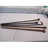 Set of five walking canes with carved handles in the shape of hands, a dog, faces, in various