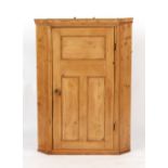 Property of a lady - a late Georgian pine corner wall cabinet with panelled door enclosing shaped