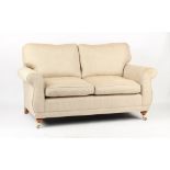 Property of a gentleman - a modern Laura Ashley two-seater sofa with turned front legs & brass