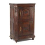 Property of a lady - a North European carved oak two-door cupboard, 18th century, with canted front,