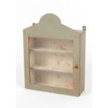 Property of a gentleman - a painted wall cabinet with glazed door enclosing floral patterned