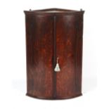 Property of a gentleman - a George III oak bow-fronted corner wall cabinet, 37.5ins. (95cms.) high.