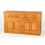 A pine dresser base with two drawers above twin panelled doors, 61.5ins. (156cms.) wide (overall).