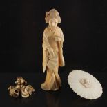 Property of a lady - an early 20th century Japanese carved ivory okimono modelled as a standing