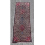 A Kordi woollen hand-made runner with beige ground, 102 by 35ins. (259 by 89cms.).