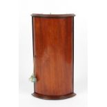 Property of a gentleman - a small mahogany bow-fronted corner wall cabinet, parts Georgian,