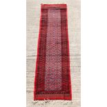 Property of a lady - an Afghan runner, with red ground, 119 by 33ins. (302 by 84cms.).