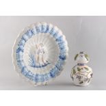 A French faience fluted dish, 18th century, painted with a maiden holding a flower, 12.2ins. (