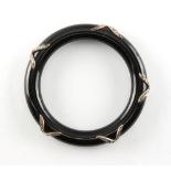 An unusual black lacquer & diamond bangle, with crossed ribbon decorations set with round cut