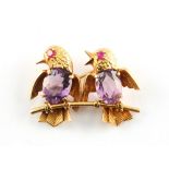 An unmarked yellow gold amethyst & ruby brooch modelled as two birds on a perch, 39mm wide,