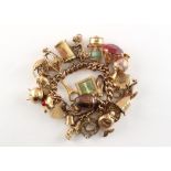 Property of a deceased estate - a 9ct gold charm bracelet, most of the gold charms hallmarked 9ct