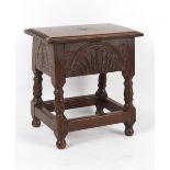 Property of a deceased estate - a carved oak box stool, with hinged lid, 17.25ins. (43.8cms.) wide.