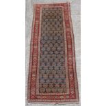 Property of a lady - an early 20th century Kurdish long rug, 116 by 42ins. (294 by 107cms.).