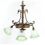 Property of a gentleman - an Edwardian brass triple ceiling light, the green tinted glass lampshades