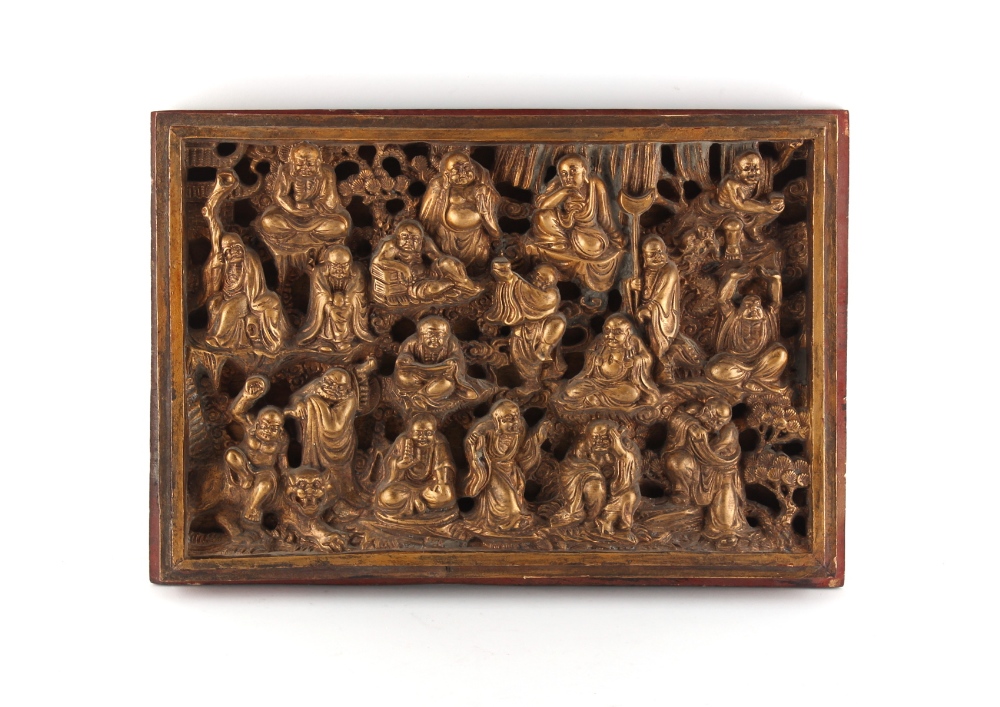 A Chinese carved giltwood & painted panel depicting eighteen various deities & figures, late 19th /