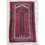 Property of a lady - an Afghan prayer rug, with red ground, 55 by 34ins. (140 by 86cms.).