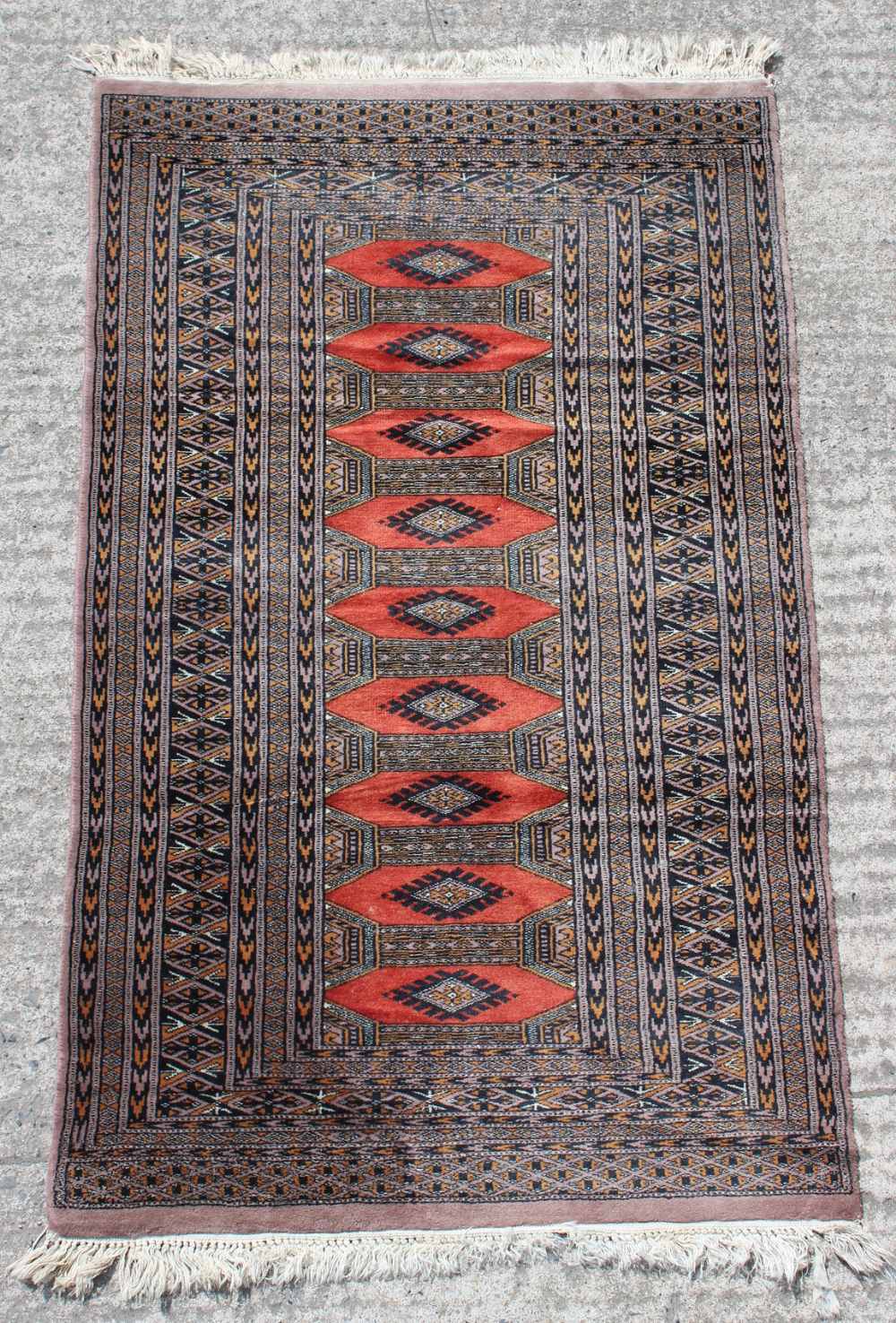 Property of a gentleman - a Tekke design hand knotted rug with red ground, 57 by 35ins. (146 by