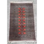Property of a gentleman - a Tekke design hand knotted rug with red ground, 57 by 35ins. (146 by
