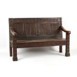 Property of a deceased estate - an 18th century & later carved oak settle, 62ins. (157.5cms.) wide.