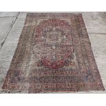 Property of a gentleman - an antique Kirman carpet, worn, 168 by 112ins. (427 by 285cms.).