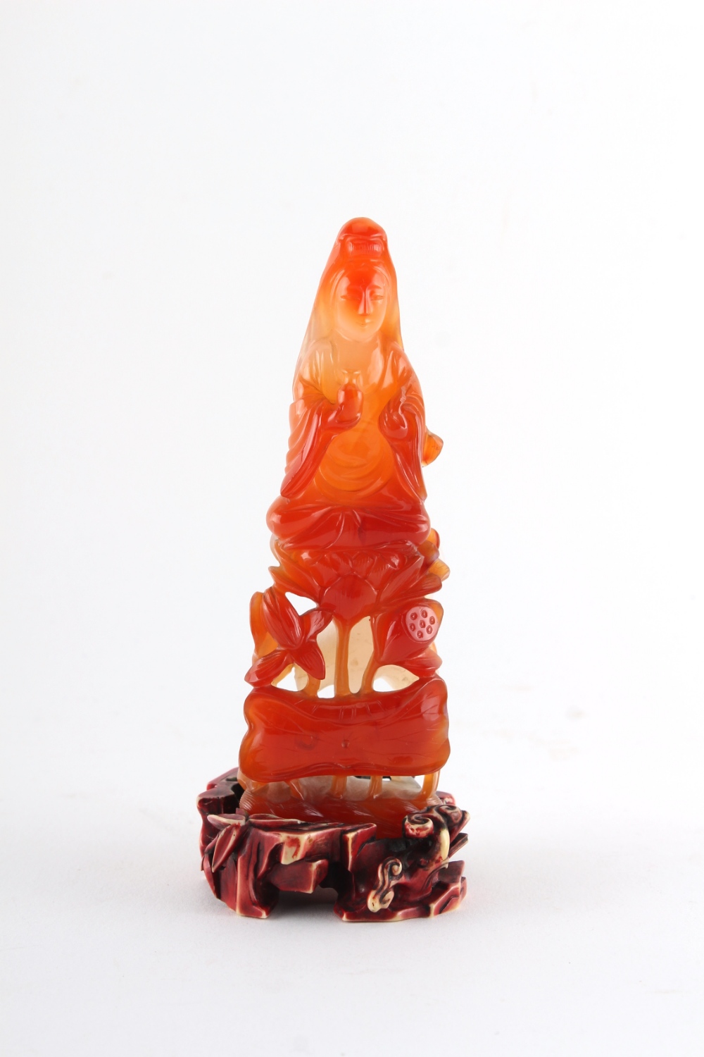 Property of a gentleman - a Chinese finely carved carnelian agate figure of Guanyin seated on