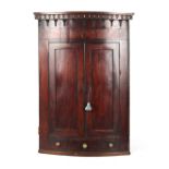 A George III mahogany & strung bow-fronted two-door corner wall cabinet, 51ins. (129.5cms.) high.