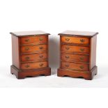 A pair of mahogany bow-fronted bedside chests of four drawers, each 19.5ins. (49.5cms.) wide (
