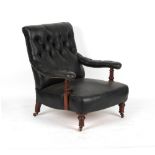 A Victorian later black leather upholstered armchair, with turned front legs & castors.