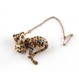 A 9ct gold multi gem set leopard brooch, with ruby eyes, sapphire spots & diamond collar, with