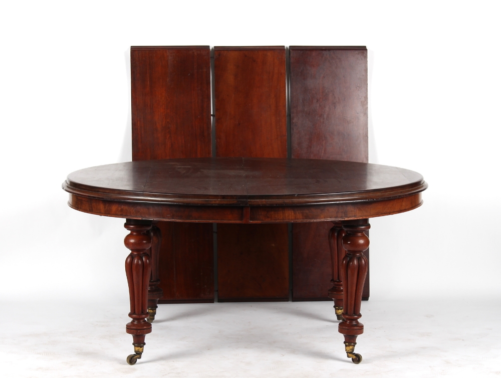 A Victorian mahogany oval topped telescopic wind-out extending dining table with three extra leaves,