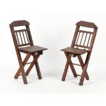 A pair of early 20th century child's oak folding chairs (2).