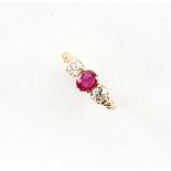 An Edwardian 18ct yellow gold ruby & diamond three stone ring, the centre oval cushion cut ruby