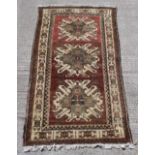 A Caucasian Kazak large rug, with brown-red ground, 121 by 67ins. (307 by 170cms.).