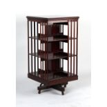 A large Edwardian mahogany three-tier revolving bookcase, 23.5ins. (59.5cms.) square, 47.25ins. (