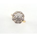 An 18ct yellow gold diamond cluster ring, with pierced millegrain setting, the centre stone