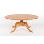 An Ercol light or blonde ash oval topped occasional table or coffee table, 48ins. (122cms.) long.