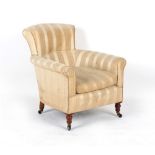 A late Victorian upholstered armchair with turned front legs & castors.