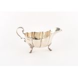 An early 20th century silver sauceboat with acanthus handle & hoof feet, London 1910,