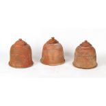 A set of three terracotta rhubarb forcers with lids, each approximately 16.5ins. (42cms.) high (