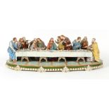 A large German Sitzendorf porcelain group depicting The Last Supper, 29ins. (74cms.) long.