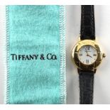 Tiffany & Co. - a lady's 18ct gold cased wristwatch, on black leather strap with 18ct gold buckle,