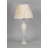 A large white alabaster table lamp, with shade, 30.25ins. (92cms.) high (overall).