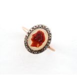 A 19th century unmarked rose gold carved hardstone cameo & diamond ring, the oval cameo depicting