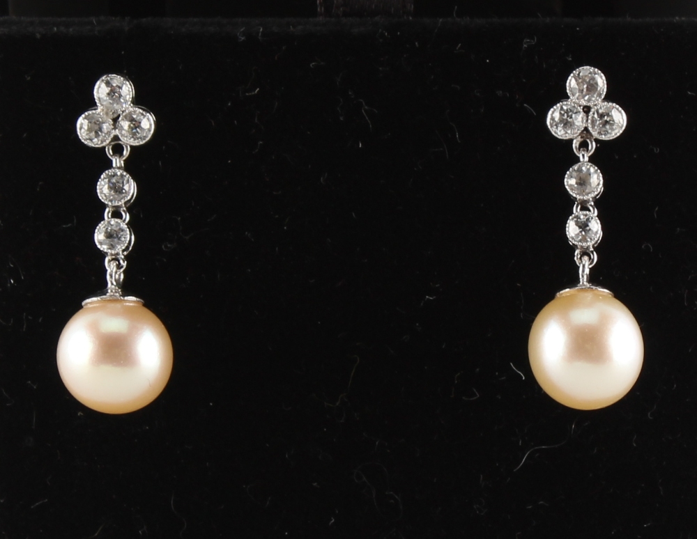 A pair of pearl & diamond earrings, with post & butterfly fastenings, each with a single untested