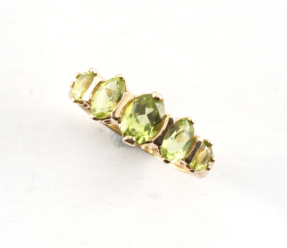 A 9ct gold ring set with five graduated oval cut peridots, size N, boxed.