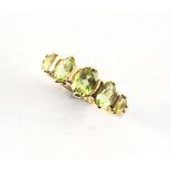 A 9ct gold ring set with five graduated oval cut peridots, size N, boxed.