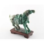 Property of a gentleman - a Chinese Tang style carved nephrite jade model of a caparisoned horse,